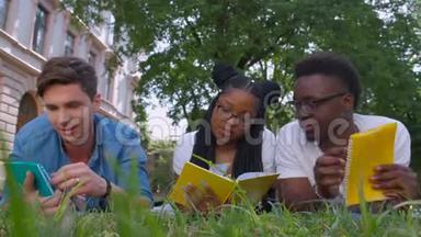 三个学生在户外坐在草地上一起学习<strong>读书笔记</strong>